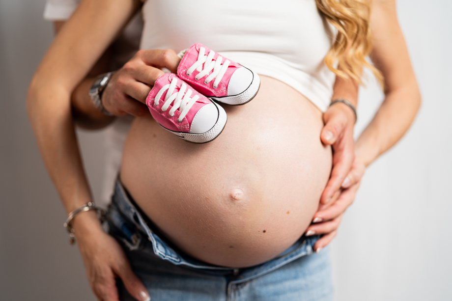 Servizio maternity scarpette bimba sul pancione rette dalle mani di mamma e papà.jpg