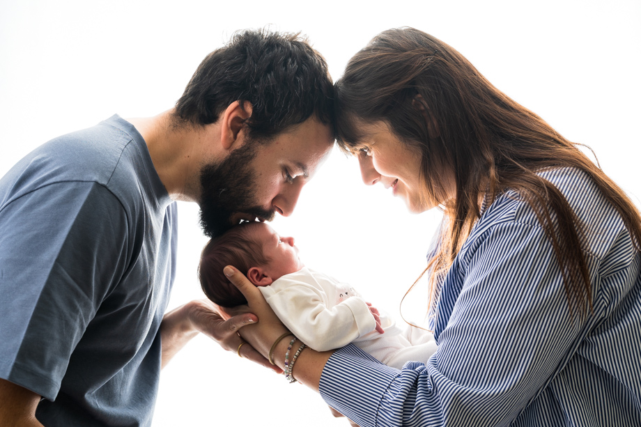 Servizio newborn family mamma e papà che tengono in braccio il neonato